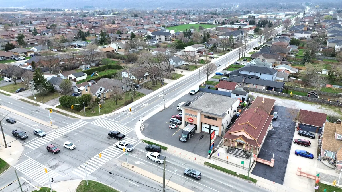 Low aerial view of No. 520 from the north, its two service bays facing Barton Street East and the Dewitt Road junction to the left