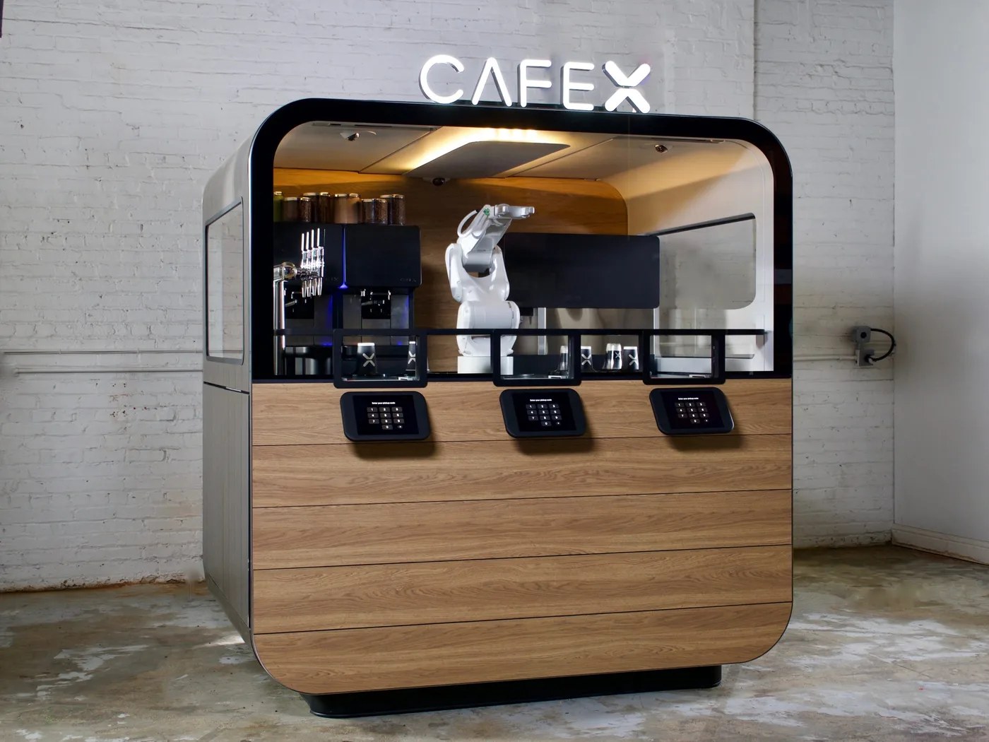 Cafe X robotic coffee kiosk with an industrial robot arm behind glass