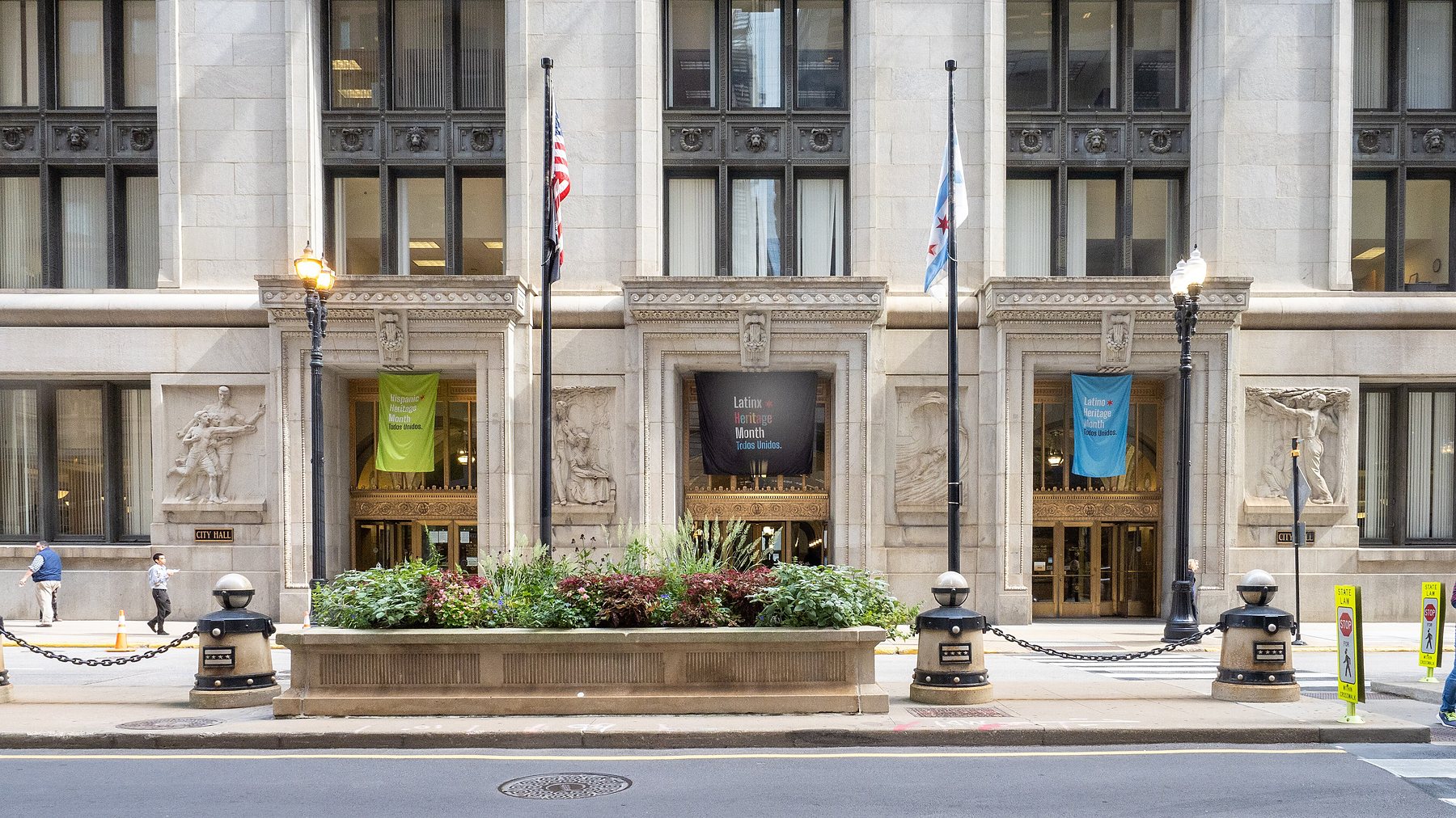 The classical granite entrance of Chicago City Hall on LaSalle Street, with flags and planters