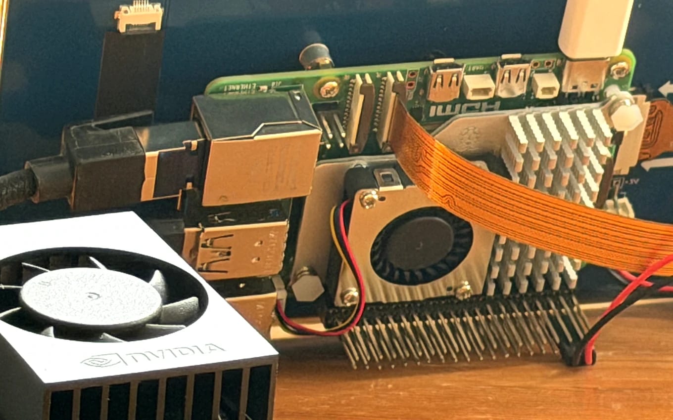 An NVIDIA-branded heatsink and fan on a Jetson-class edge computer, wired up on a workbench beside the board.